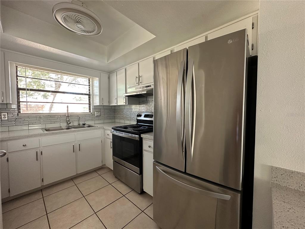 6104 Topher Trail, Unit 6104 Mulberry, FL 33860 - Photo 7 of 19 a kitchen with granite countertop stainless steel appliances a refrigerator sink and cabinets