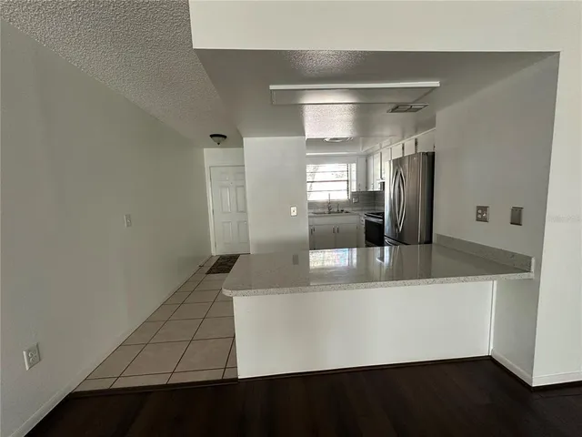 a view of a refrigerator in kitchen and wooden floor