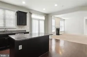 a kitchen with granite countertop a sink a stove and cabinets