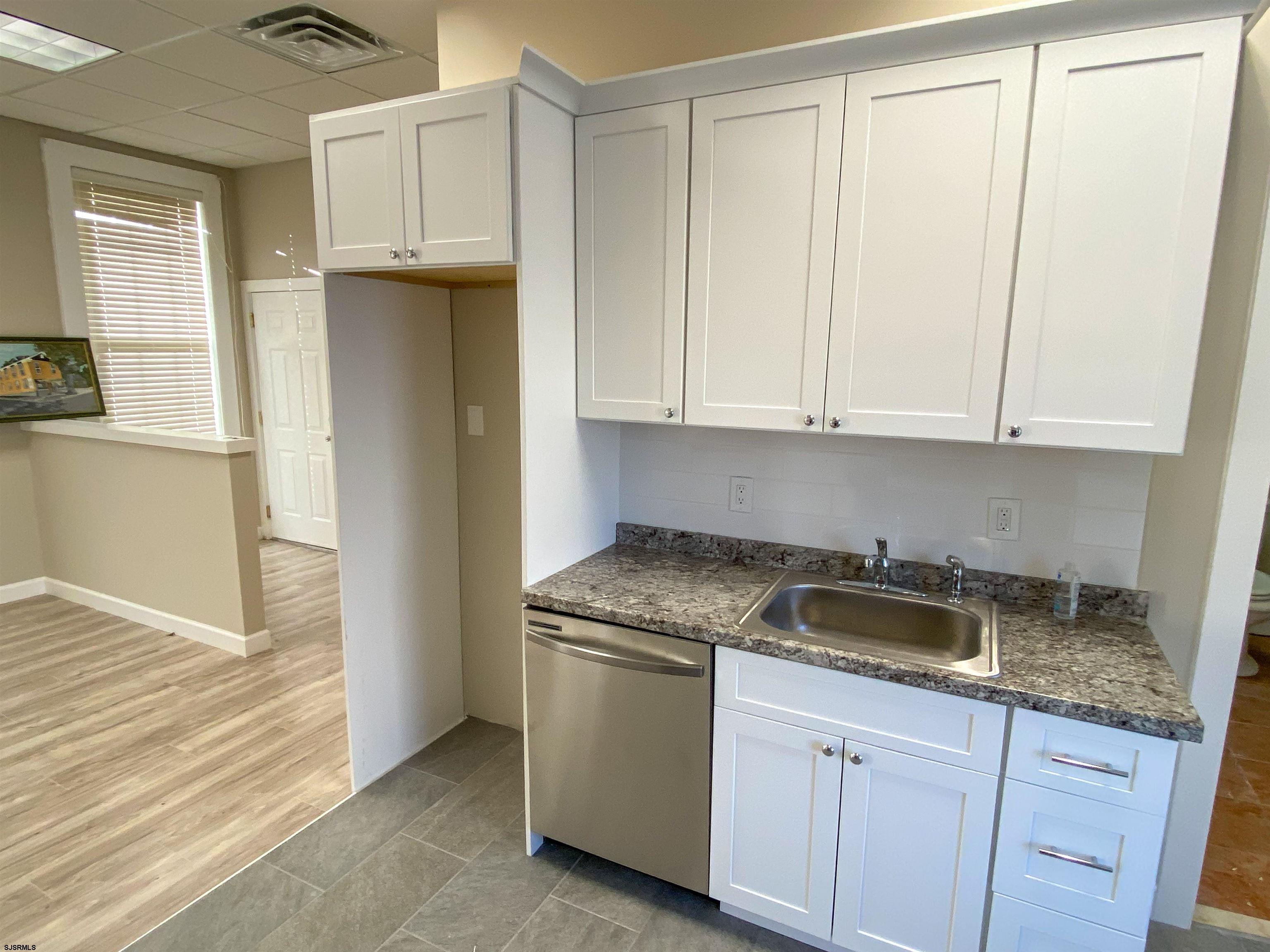 6019 Main Street, Unit 2 Mays Landing, NJ 08330 - Photo 11 of 26 a kitchen with granite countertop white cabinets and a sink