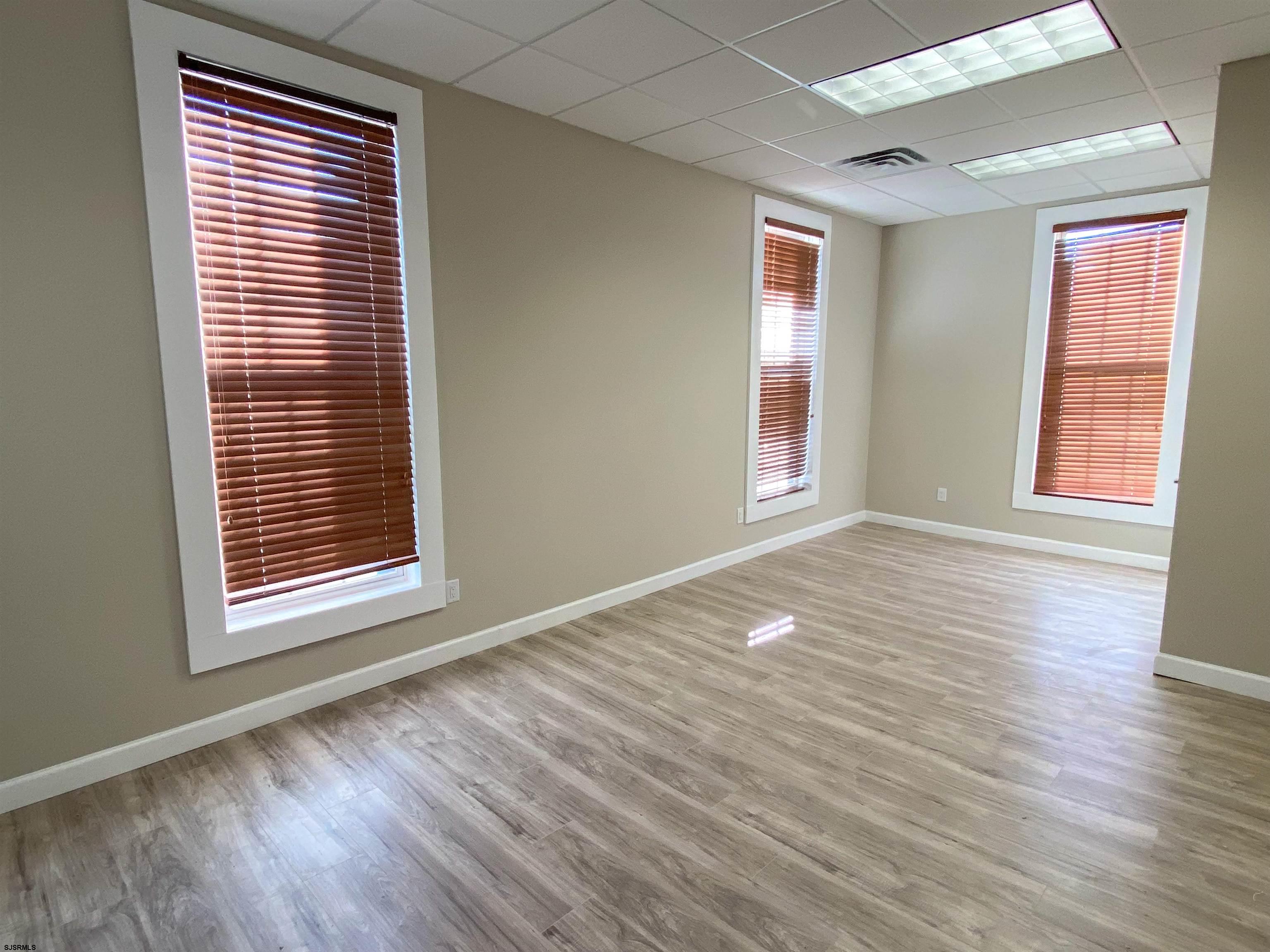 6019 Main Street, Unit 2 Mays Landing, NJ 08330 - Photo 13 of 26 a view of an empty room with wooden floor and a window