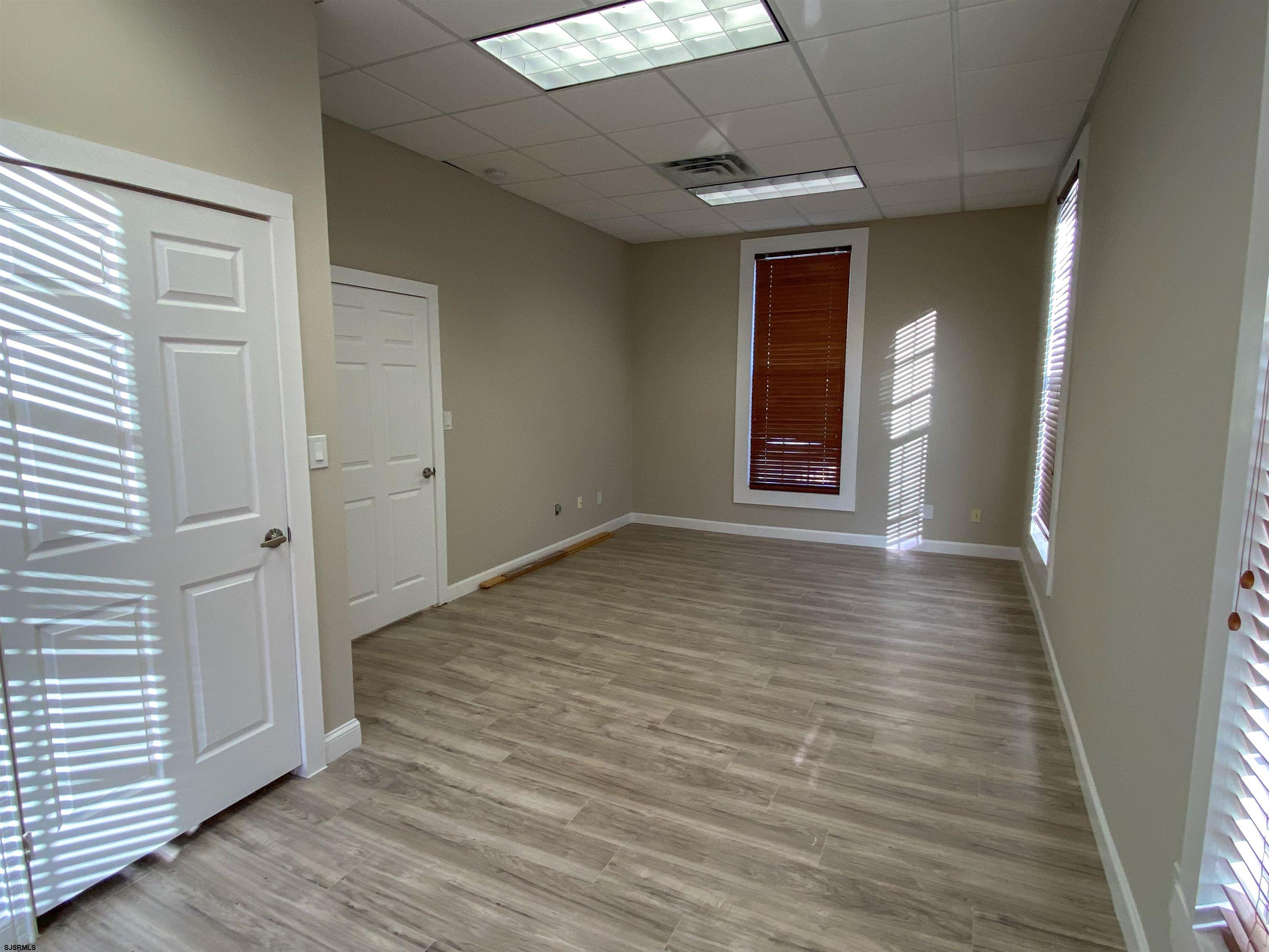 6019 Main Street, Unit 2 Mays Landing, NJ 08330 - Photo 15 of 26 an empty room with wooden floor and windows