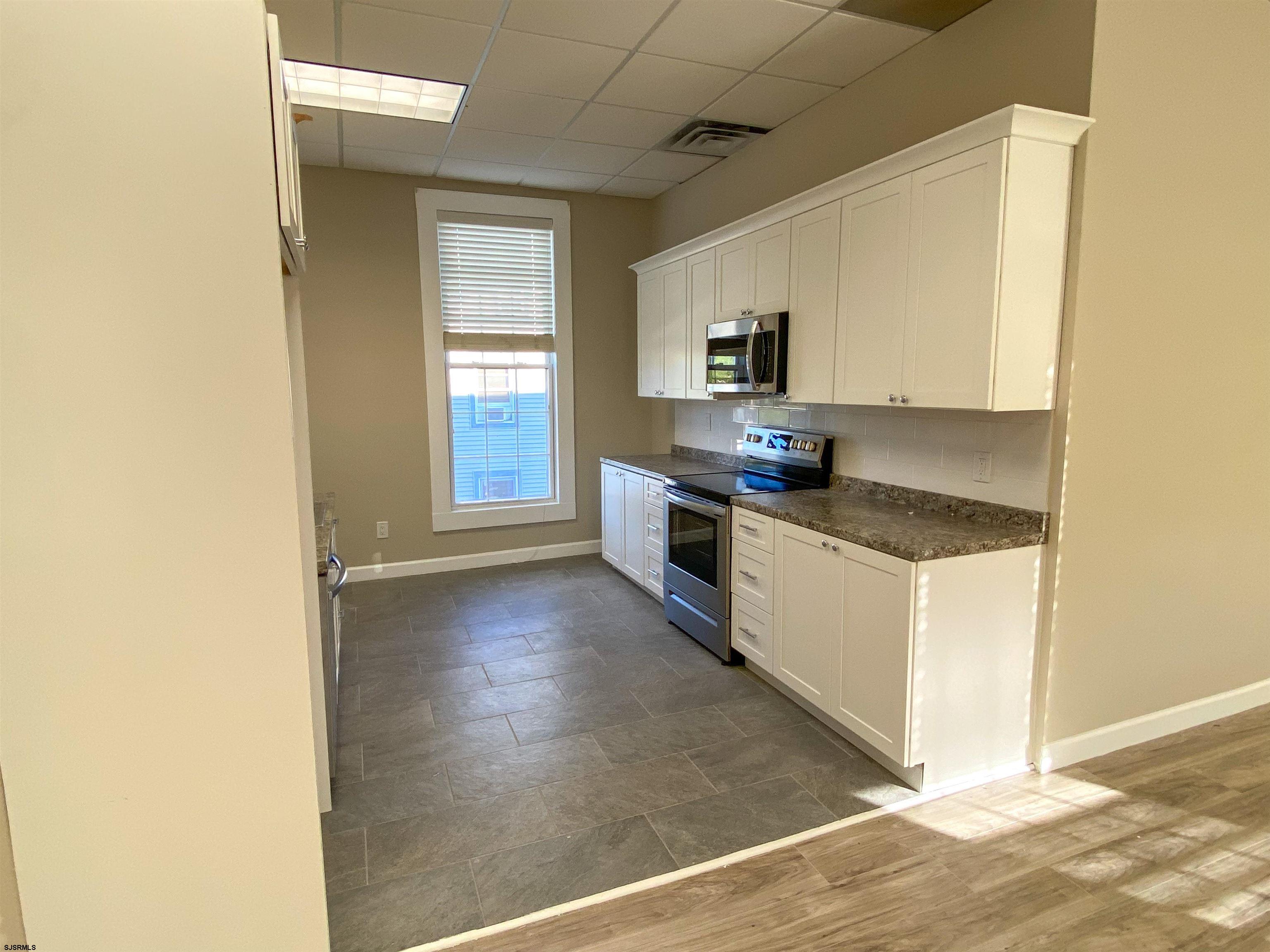 6019 Main Street, Unit 2 Mays Landing, NJ 08330 - Photo 10 of 26 a kitchen with granite countertop a stove a sink and a refrigerator