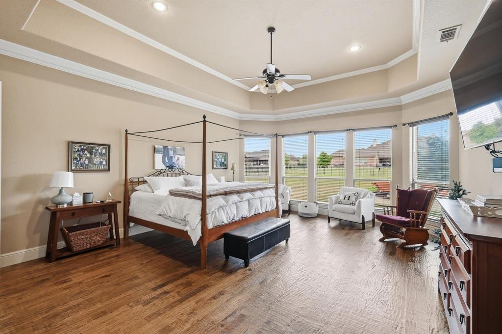 406 Spurgin Road Lucas, TX 75002 - Photo 15 of 39 Bedroom featuring dark wood-style flooring, ceiling fan, a raised ceiling, and crown molding