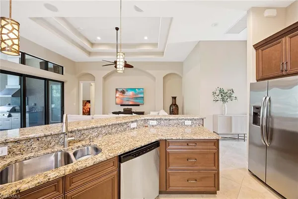 a kitchen with stainless steel appliances granite countertop a sink and a refrigerator