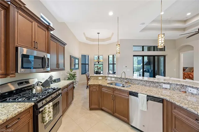 a large kitchen with stainless steel appliances granite countertop a stove and a sink