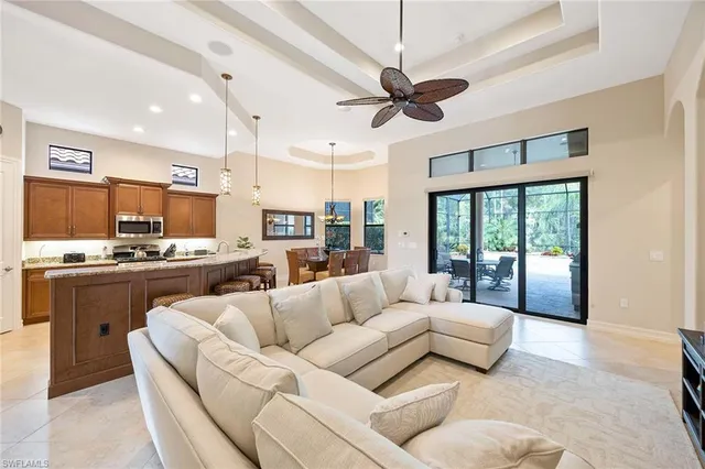 a living room with furniture and a large window with kitchen view