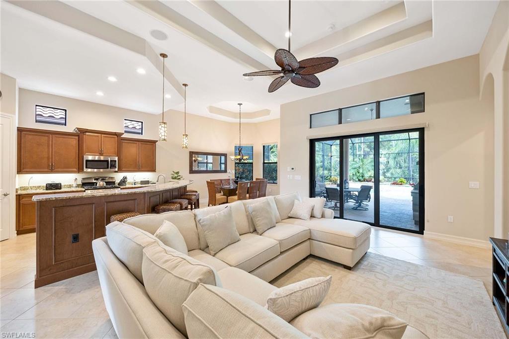 6255 Brunello Lane Naples, FL 34113 - Photo 13 of 37 a living room with furniture and a large window with kitchen view