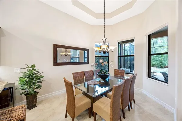 a dining room with furniture a chandelier and window