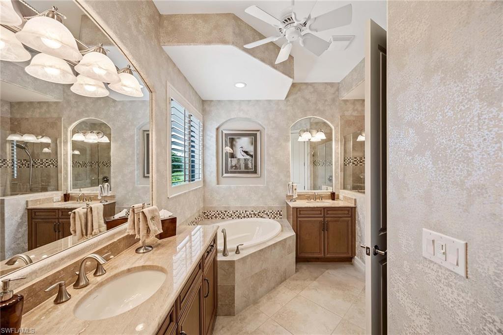 6255 Brunello Lane Naples, FL 34113 - Photo 16 of 37 a spacious bathroom with a granite countertop sink mirror and bathtub