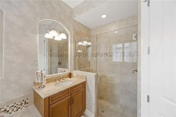 a bathroom with a sink mirror and a shower
