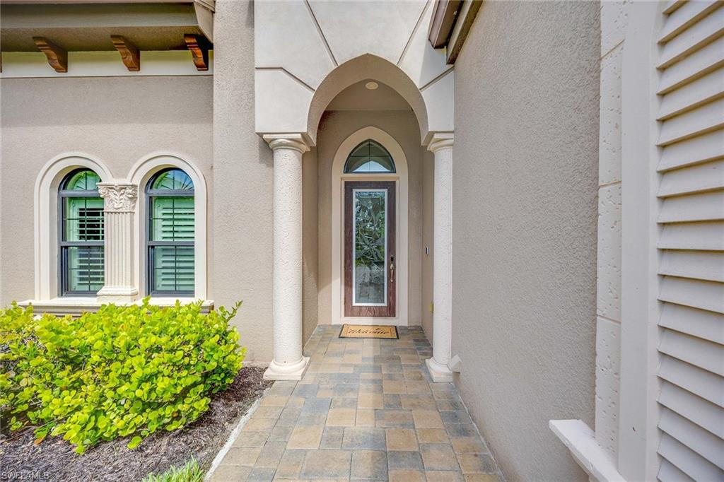 6255 Brunello Lane Naples, FL 34113 - Photo 3 of 37 a view of a brick house with potted plants
