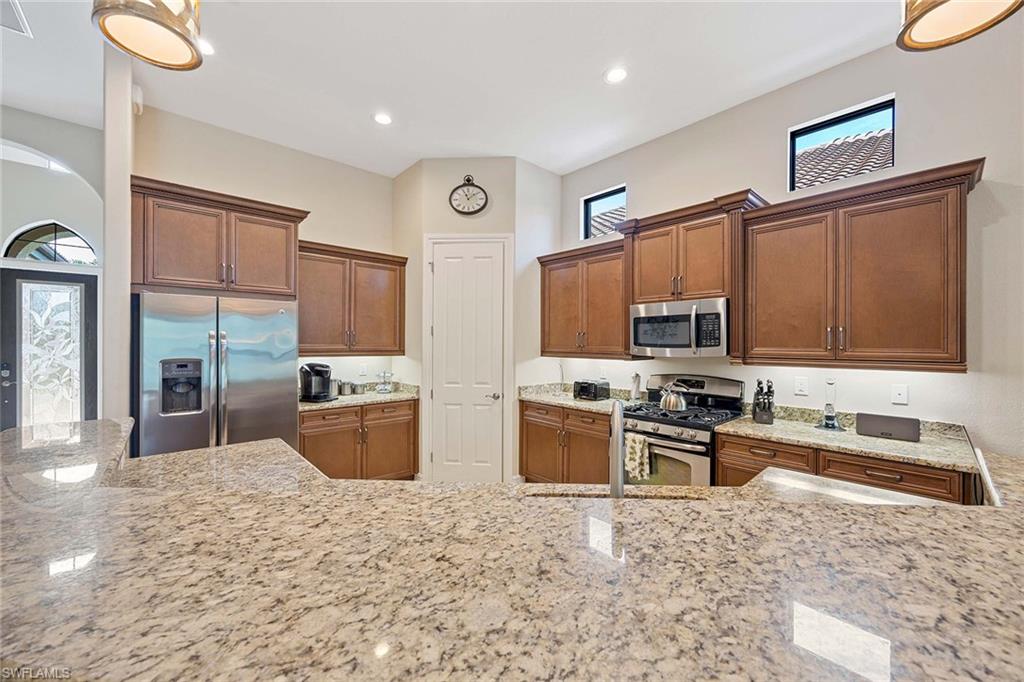6255 Brunello Lane Naples, FL 34113 - Photo 10 of 37 a kitchen with a refrigerator stove top oven and sink
