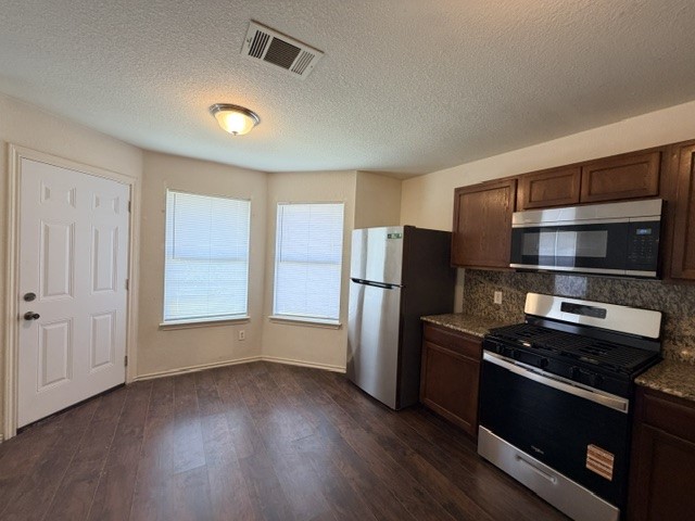 18421 Crestwind Lane Elgin, TX 78621 - Photo 18 of 34 Rich wood cabinetry and stainless steel appliances complete this inviting kitchen space.