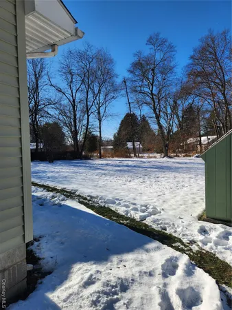a view of a yard covered with snow in front of house