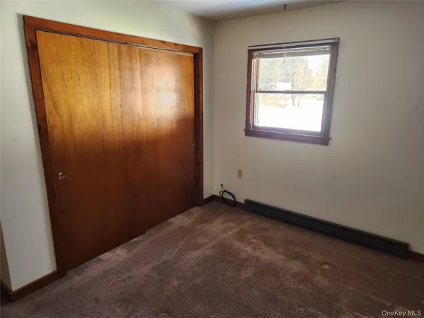 an empty room with windows and closet