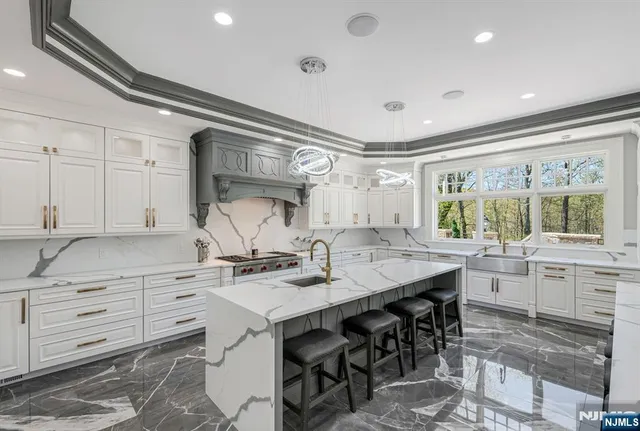 a kitchen with granite countertop a sink chairs and cabinets