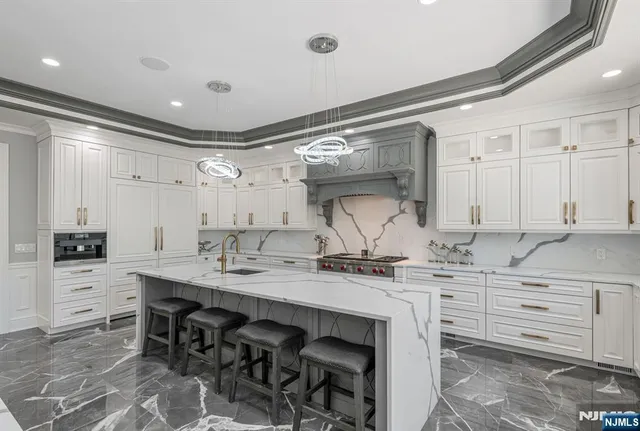 a kitchen with stainless steel appliances granite countertop a table chairs sink and cabinets