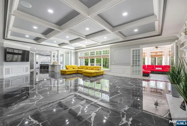 a room with lots of white furniture and chandelier