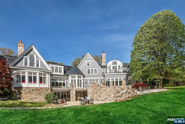 a view of a house with a yard and a large tree