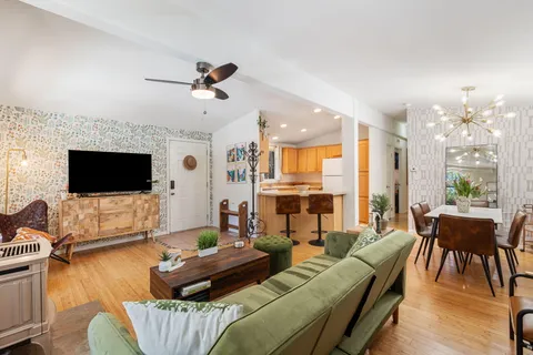 a living room with furniture a flat screen tv and a fireplace