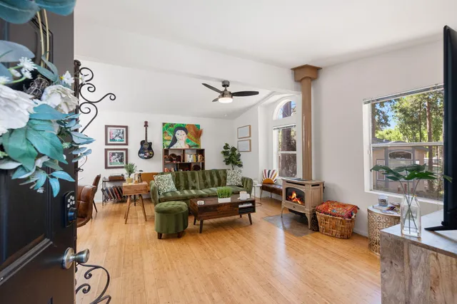 a living room with furniture a flat screen tv and a window