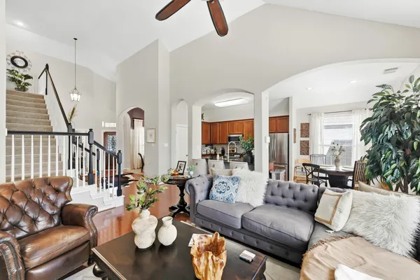 a living room with furniture kitchen view and a large window