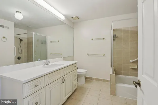 a spacious bathroom with a shower sink and mirror