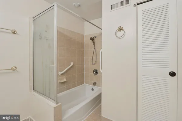 a bathroom with a tub shower and vanity