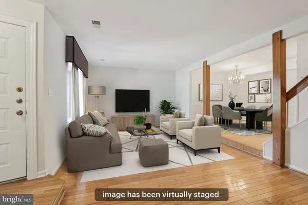 a living room with furniture wooden floor and a flat screen tv