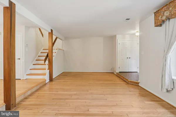 a view of an empty room with stairs and a floor to ceiling window