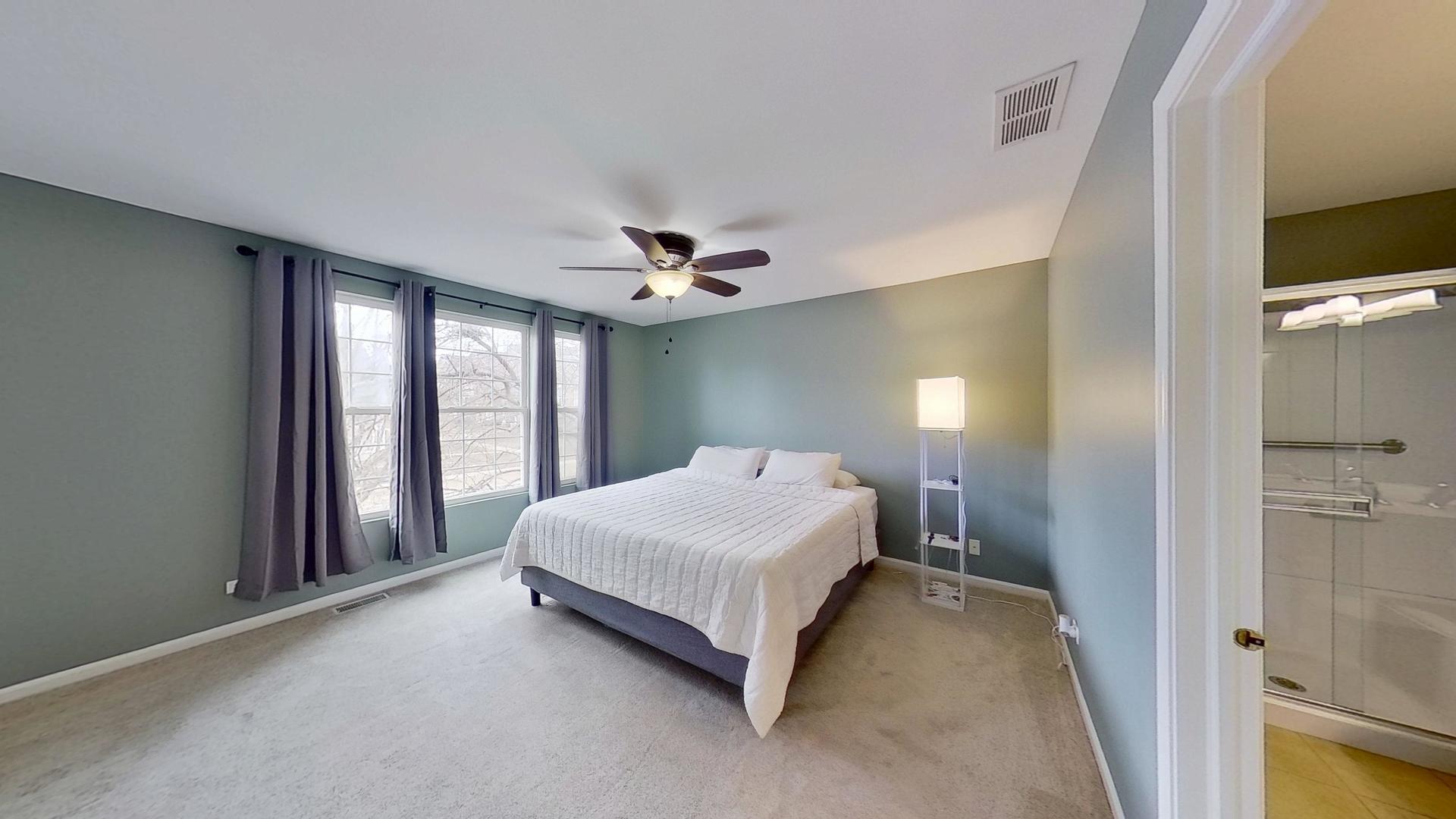 2418 Emily Lane Elgin, IL 60124 - Photo 10 of 27 a spacious bedroom with a bed and a flat tv screen on dresser