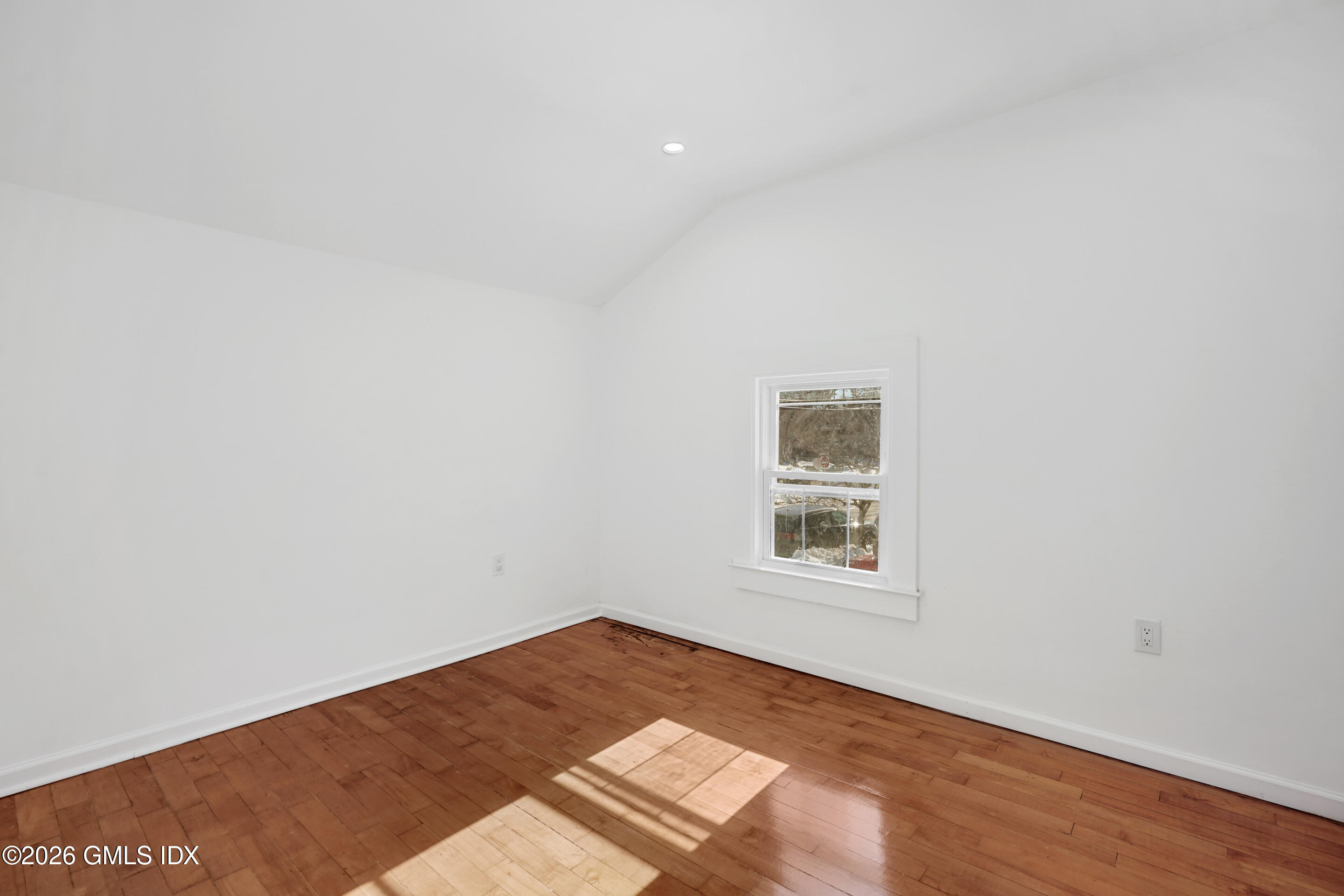 212 Davis Avenue, Unit B Greenwich, CT 06830 - Photo 7 of 10 an empty room with wooden floor and windows