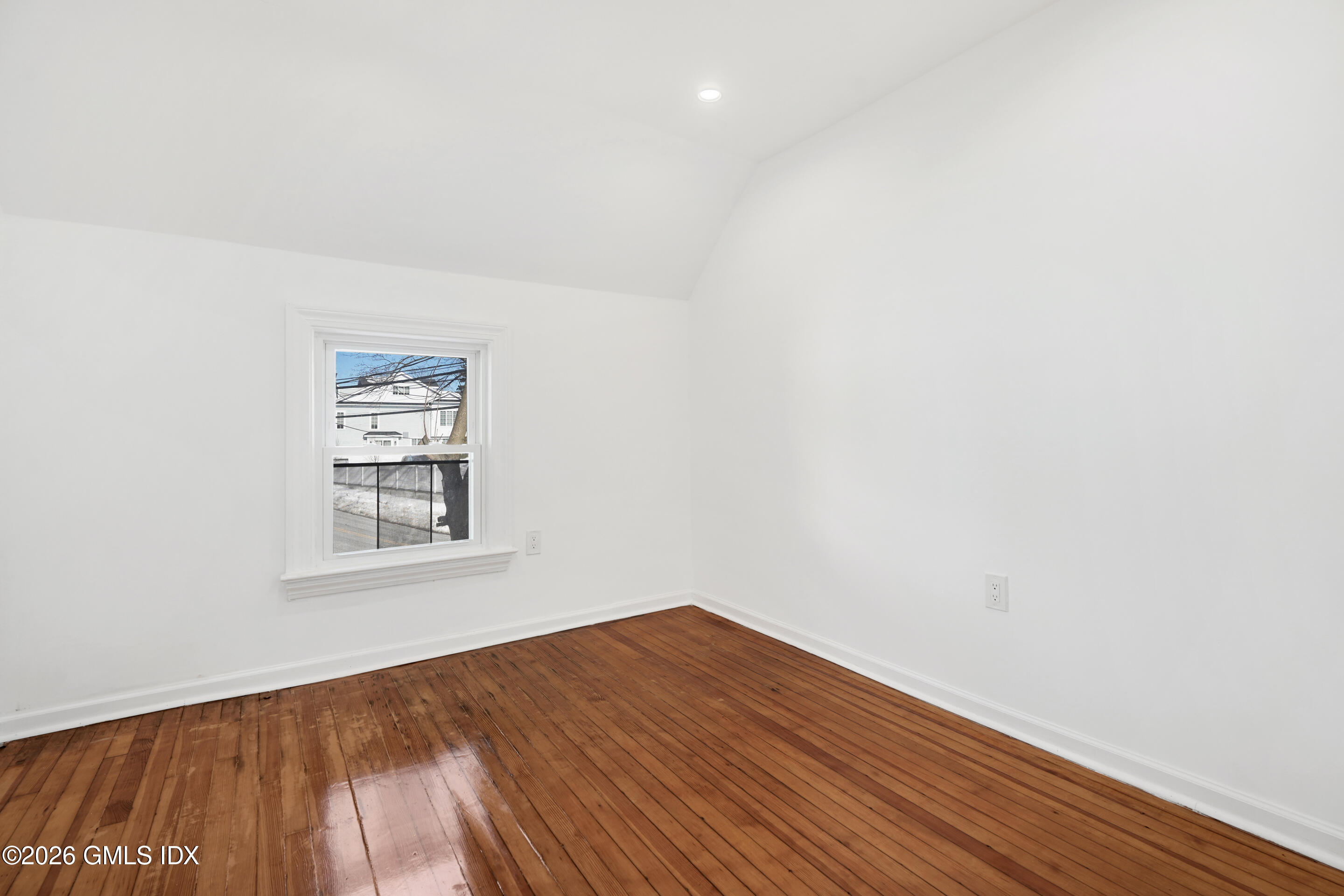 212 Davis Avenue, Unit B Greenwich, CT 06830 - Photo 8 of 10 a view of an empty room with wooden floor and a window