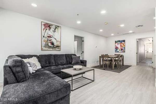 a living room with furniture and a wooden floor