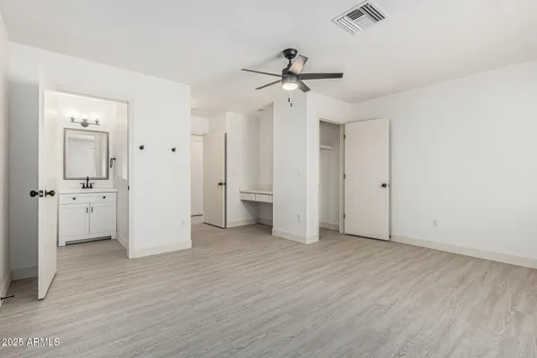a kitchen with white cabinets and sink