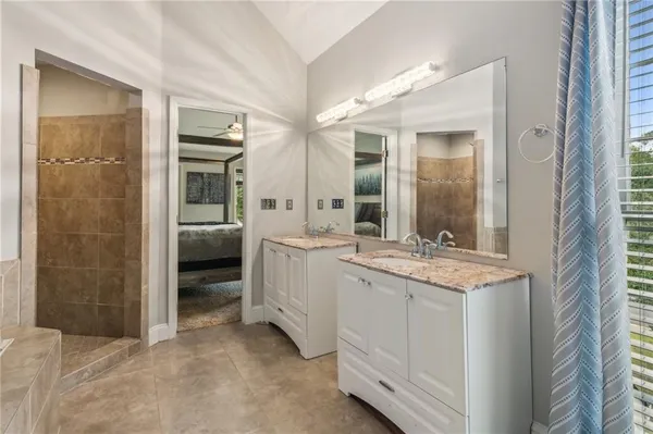 a bathroom with a granite countertop sink a mirror and a shower