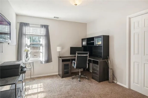 a view of a workspace with furniture and a window