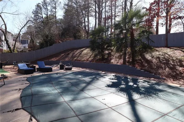 a view of backyard with swimming pool and trees