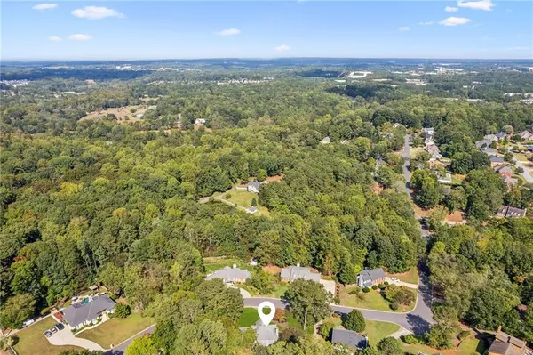 an aerial view of residential houses with outdoor space and trees