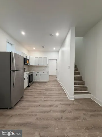 a view of kitchen with wooden floor and electronic appliances