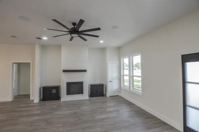 an empty room with windows and a fireplace