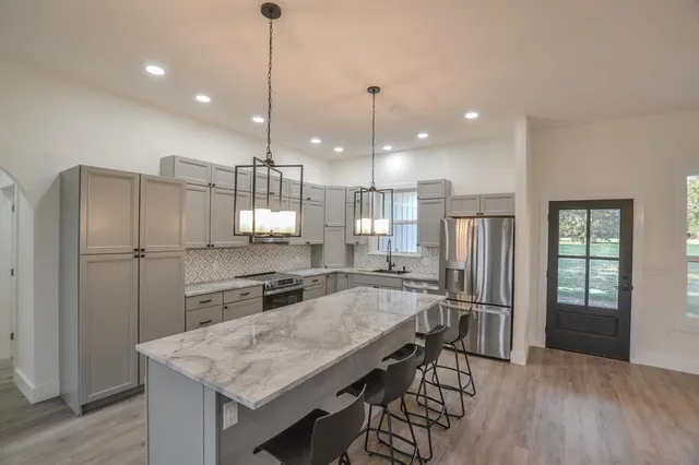 a kitchen with refrigerator cabinets and wooden floor