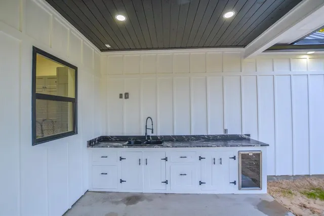 a view of a utility room with granite countertop cabinets and a window