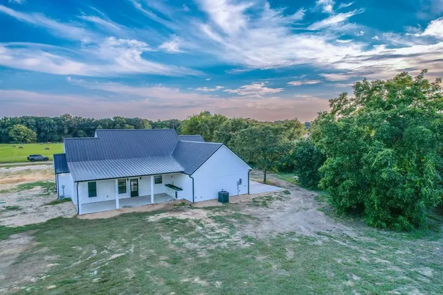 a aerial view of a house next to a big yard