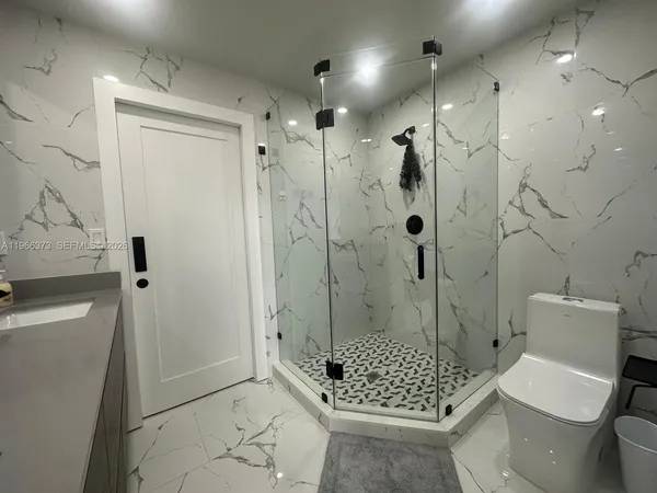 a bathroom with a shower a toilet and sink