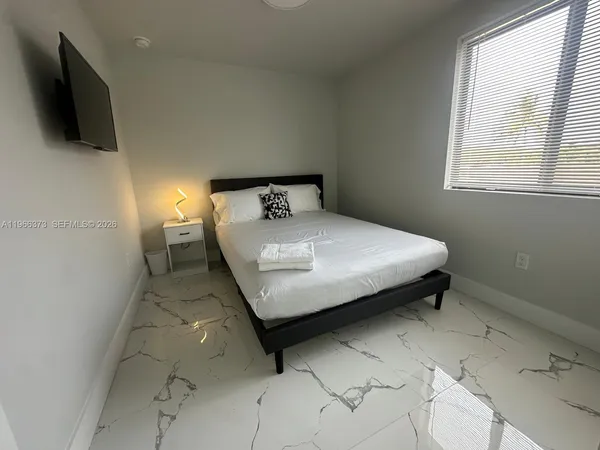 a bedroom with a bed and flat screen tv