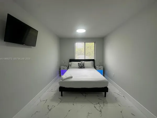 a bedroom with a bed and a flat screen tv