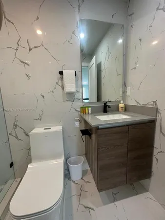 a bathroom with a sink toilet vanity and shower