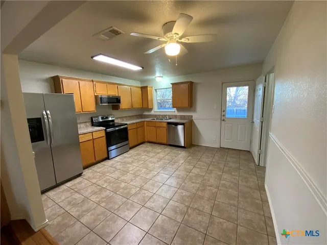 a large kitchen with cabinets and stainless steel appliances